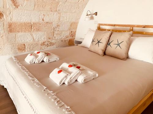 a bed with towels and pillows on it at Stella Marina Luxury in Polignano a Mare