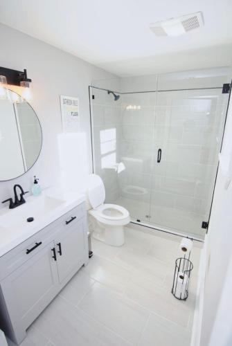 La salle de bains blanche est pourvue d'une douche et de toilettes. dans l'établissement Treme Treasure, à La Nouvelle-Orléans