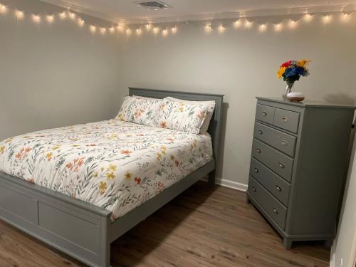 a bedroom with a bed and a dresser and lights at My little place in Stratford