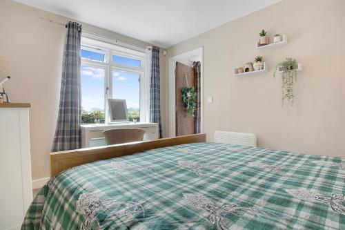 a bedroom with a bed with a green and white blanket at Frenchgate Holiday Stay in Richmond
