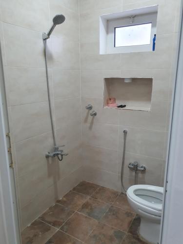 ein Bad mit einer Dusche und einem WC in der Unterkunft ستوديو دور ارضي كامل بمطبخ وحوش وكراج خاص. in Al Hofuf