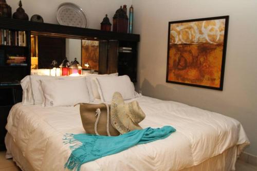 Un dormitorio con una cama blanca con sombreros. en Sapphire del Mar B-106 Ocean Front Beach Level, en Nazareth