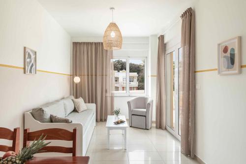 sala de estar con sofá y silla en Artemis Apartments en Stalos