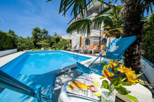 una piscina con tavolo e sedie accanto a una casa di Villa Marea a Rovigno (Rovinj)