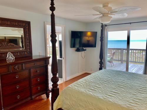 1 dormitorio con cama, tocador y espejo en Beach House en Clearwater Beach