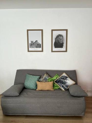 a gray couch with pillows on it in a living room at Le building: 5 pax centre ville in Marseille