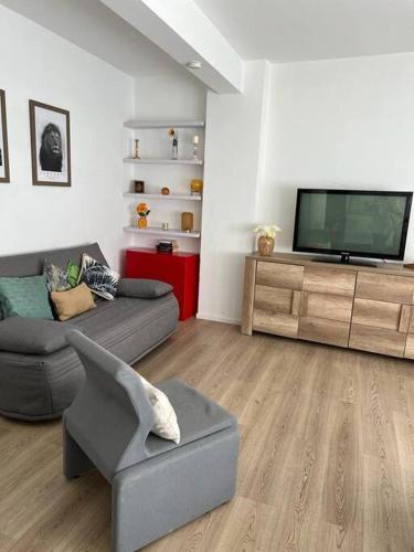 a living room with a couch and a television at Le building: 5 pax centre ville in Marseille