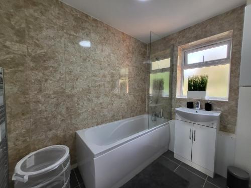 uma casa de banho com uma banheira, um WC e um lavatório. em Stylish Flat - Great location for Contractors, Families, Relocators, Business, Free Parking, Long-Stays em Banbury