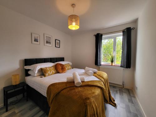 a bedroom with a large bed with a window at Stylish Flat - Great location for Contractors, Families, Relocators, Business, Free Parking, Long-Stays in Banbury