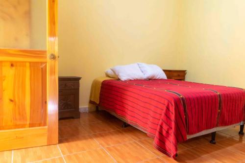 a room with a bed with a red blanket at Casa Esperanza in Panajachel