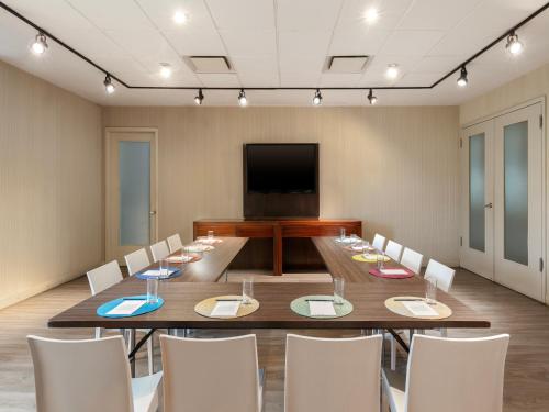 a conference room with a table and chairs and a television at Aloft Bogotá Airport in Bogotá