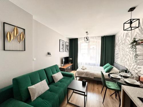 カトヴィツェにあるKościuszki BENJAMIN'S Apartmentsのリビングルーム(緑のソファ、ベッド付)