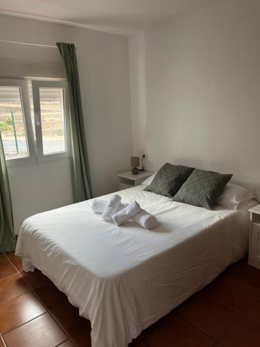 a bedroom with a large white bed with towels on it at Tamaragua Tenerife South Beach Bungalows in Arona