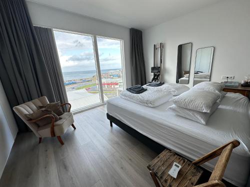 a bedroom with a large bed and a large window at Luxury apartment Mýrargata - Birta Rentals in Reykjavík
