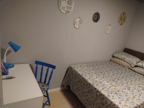 a bedroom with a bed and a table and a chair at Apartamento London - Centro Nova Petrópolis in Nova Petrópolis