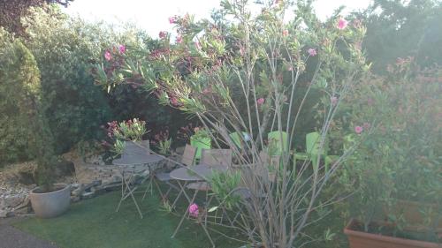 a garden with a table and chairs and flowers at A&H PRIVILÈGE Lyon Est - Saint Priest Eurexpo in Saint-Priest
