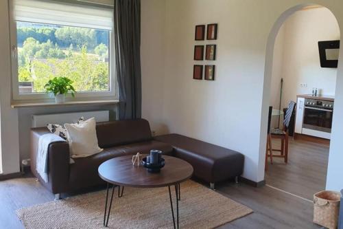 a living room with a couch and a table at Green hills holiday house in Warmensteinach