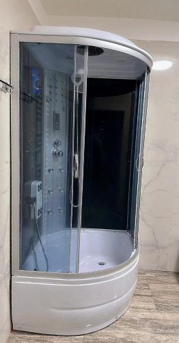a shower sitting in a room with at Kiwi apartment in Bistriţa