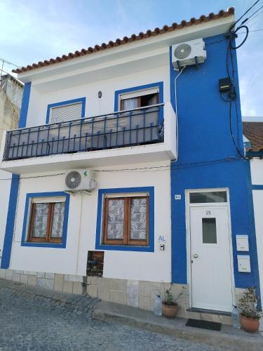 un edificio azul y blanco con balcón en Casa da laranjeira, en Montargil