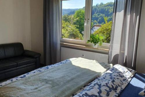 a bedroom with a bed and a large window at Green hills holiday house in Warmensteinach