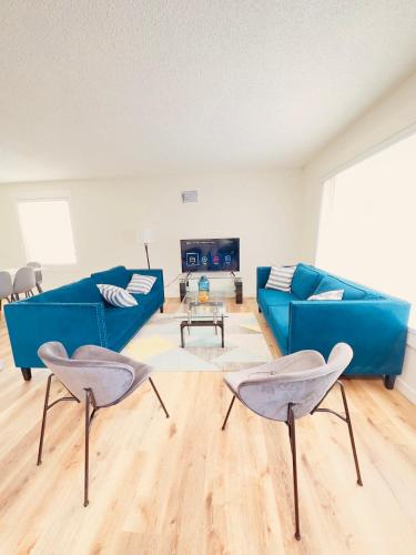 a living room with a blue couch and two chairs at Entire 3 bedroom house in Edmonton