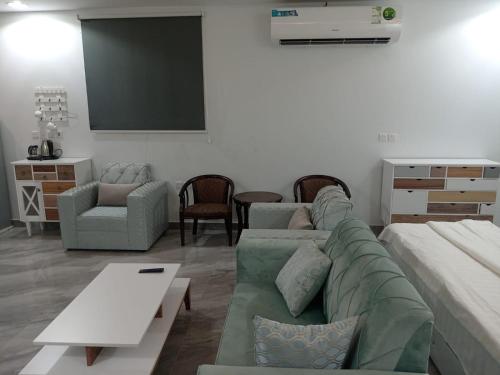 ein Wohnzimmer mit einem Sofa und einem Flachbild-TV in der Unterkunft هدي هوم 2 in Buraida