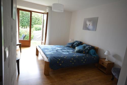 Schlafzimmer mit einem Bett mit blauer Decke in der Unterkunft Gîte de Crêt Vial in Alby