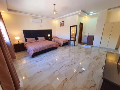 een slaapkamer met 2 bedden en een marmeren vloer bij iHome Petra in Wadi Musa