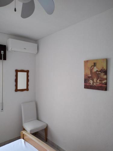 a room with a chair and a painting on the wall at Casa da laranjeira in Montargil