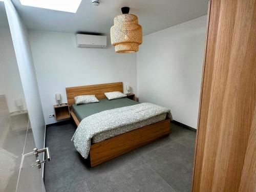 a small bedroom with a bed and a light at Akuta City Flat Leuven in Leuven