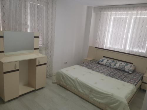 een kleine slaapkamer met een bed en een televisie bij URBAN1 Ferizaj City in Ferizaj