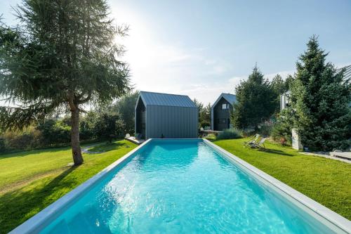 a swimming pool in the yard of a house with a shed at SKARPA resort in Ustronie Morskie