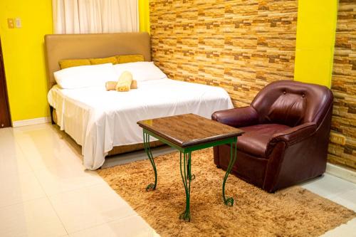 1 dormitorio con 1 cama, 1 silla y 1 mesa en Amor Building - Urdaneta City 