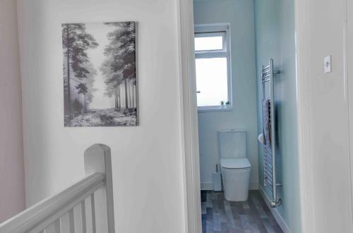 a bathroom with a toilet and a picture on the wall at Grove House Southend on Sea in Southend-on-Sea