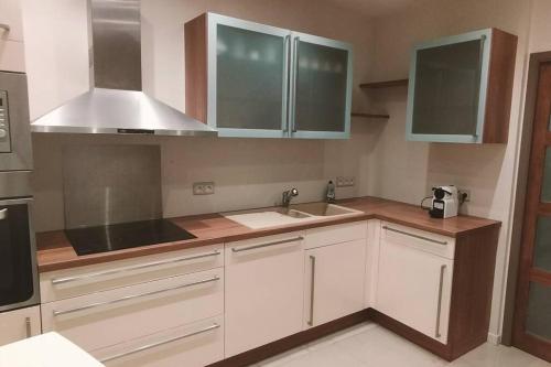 a kitchen with white cabinets and a sink at Appartement au pied du château in Montbéliard