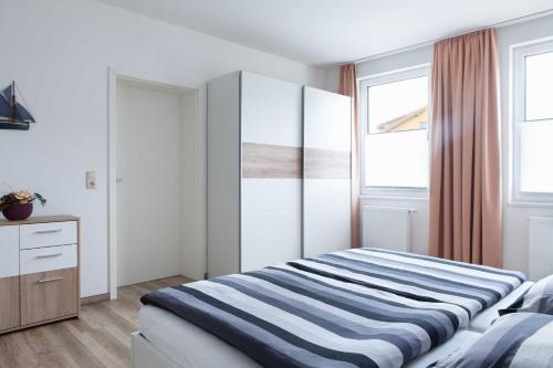 1 dormitorio con 1 cama, vestidor y 2 ventanas en Ferienunterkünfte Liliane, en Göhren