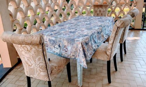 un tavolo con sedie e una tovaglia blu sopra di VILLA ÉMERAUDE a Yaoundé