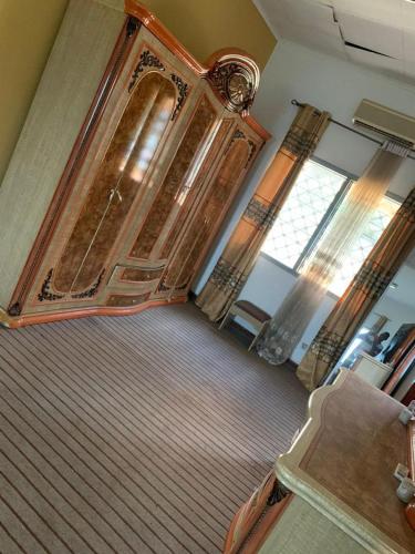 a bedroom with a large wooden bed and a window at VILLA ÉMERAUDE in Yaoundé