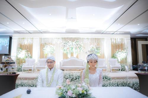a bride and groom standing in front of a altar at Crowne Plaza Bandung by IHG in Bandung