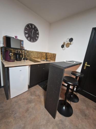 une cuisine avec une table et une horloge au mur dans l'établissement Suite GOLD Mulhouse, à Mulhouse