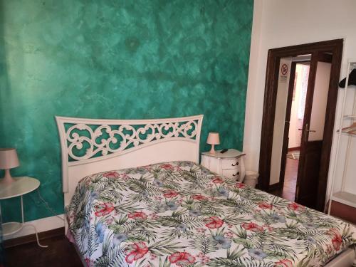 ein Schlafzimmer mit einem Bett und einer grünen Wand in der Unterkunft La casa di Circe in Triest