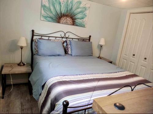 1 dormitorio con 1 cama grande con almohadas azules en Chalet chez Divine!, en Trois-Rivières