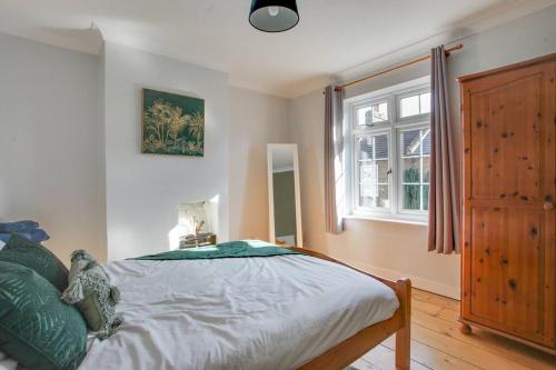 a bedroom with a bed and a window at Roman Cottage Chelmsford in Chelmsford