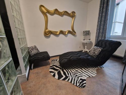 a living room with two chairs and a mirror at Suite GOLD Mulhouse in Mulhouse