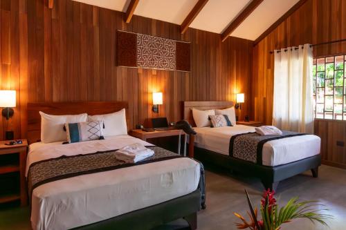 プカルパにあるWAKAYA ECOLODGEの木製の壁の部屋にベッドが2つある