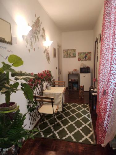 un soggiorno con tavolo, sedie e una pianta di La casa di Circe a Trieste