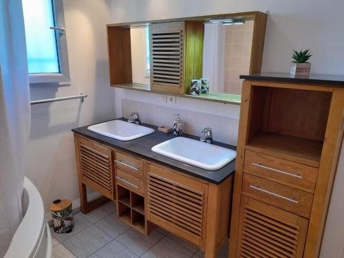 une salle de bain avec deux lavabos et un miroir dans l'établissement Le mas des Landes, à Vielle-Saint-Girons