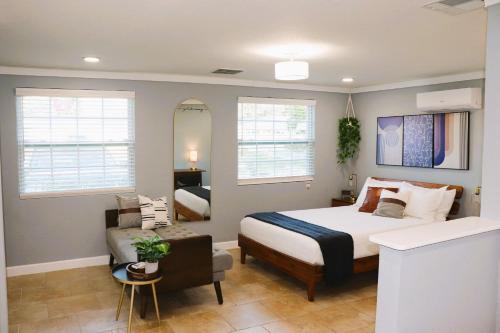 a bedroom with a bed and a chair and a mirror at Luxury Studio Suite close to Tampa Airport in Tampa