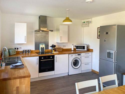 a kitchen with white cabinets and a washer at Millers Rest in Hickling