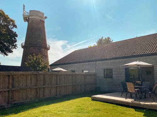 a backyard with a wooden fence and a lighthouse at Millers Rest in Hickling